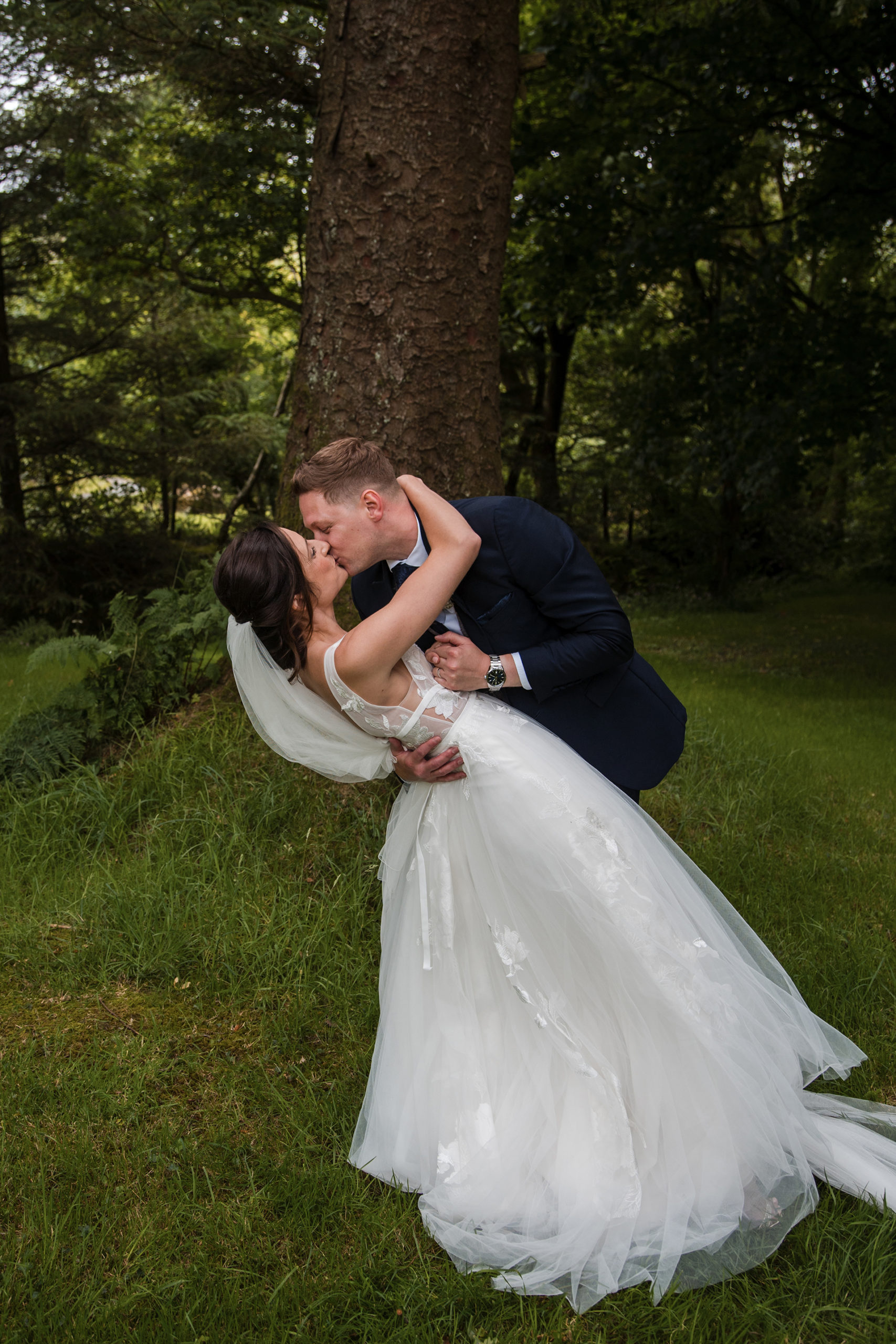 Alison and matt kissing at their woodland wedding wales