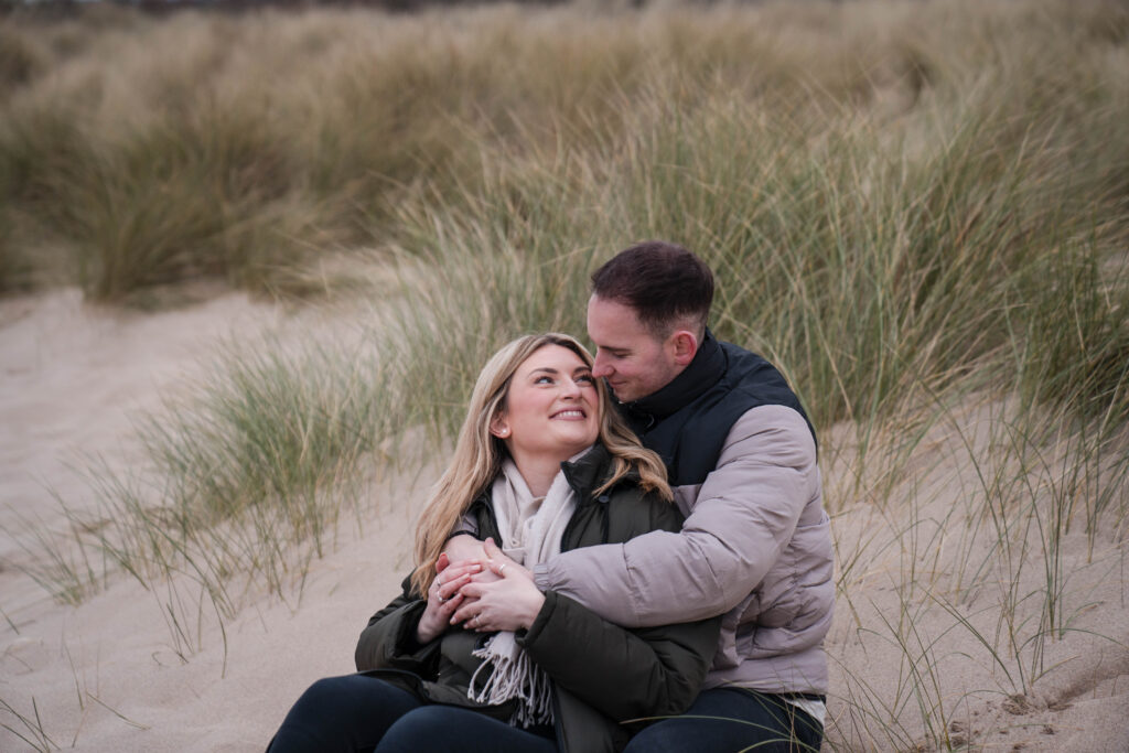 Engagement photo of couple in sand dunes at Broad Haven South, Pembrokeshire, West Wales. 